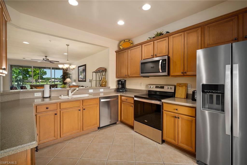 9113 Michael Circle, Unit 4 Naples, FL 34113 - Photo 8 of 23 Kitchen with kitchen peninsula, ceiling fan, appliances with stainless steel finishes, sink, and pendant lighting