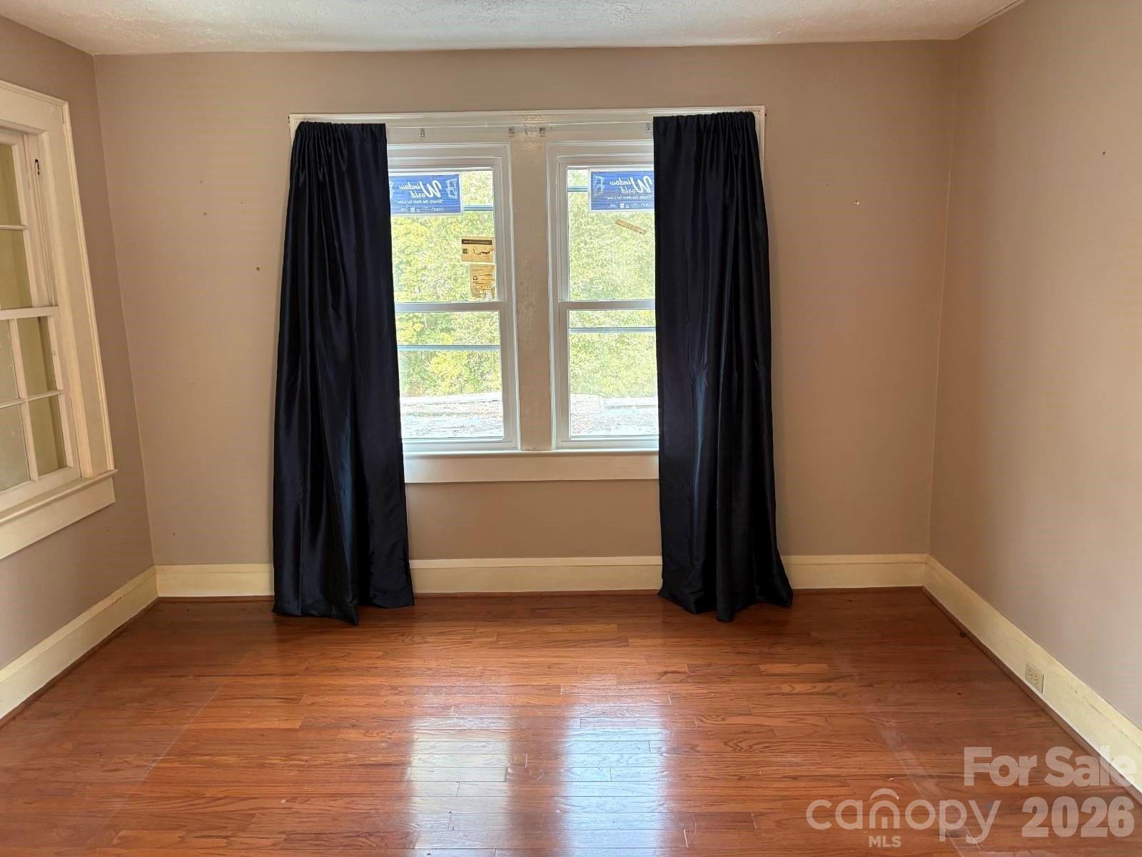 1507 Fayetteville Road Rockingham, NC 28379 - Photo 11 of 28 an empty room with wooden floor and windows