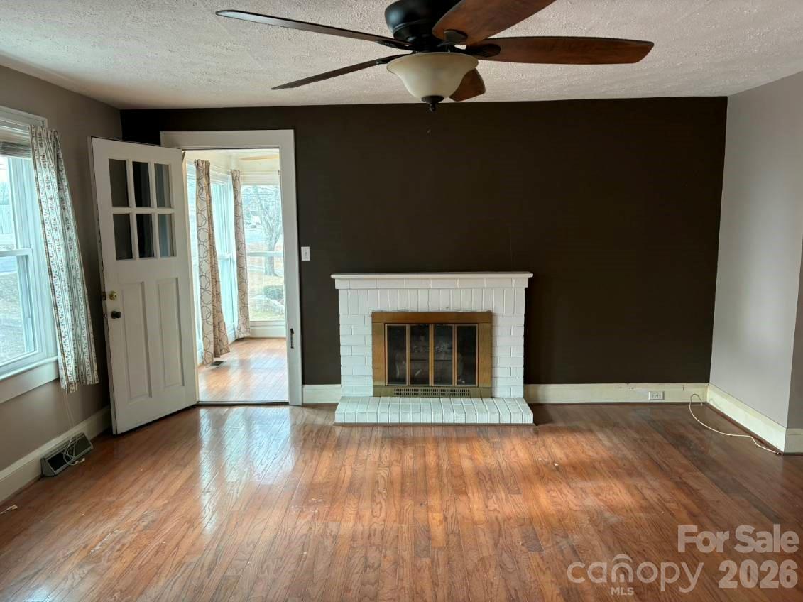 1507 Fayetteville Road Rockingham, NC 28379 - Photo 3 of 28 wooden floor fireplace and windows in an empty room