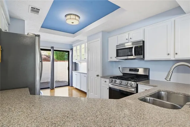 a kitchen with granite countertop a stove a sink and a microwave