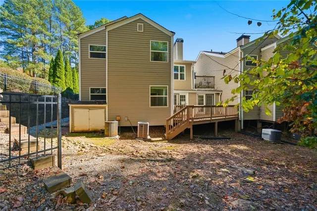 a view of a backyard with table and chairs potted plants and a large tree