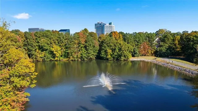 front view of a house with potted plants and large trees