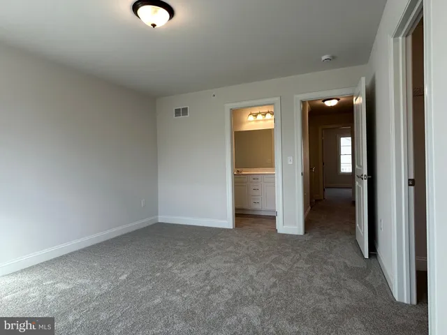 an empty room with closet and a bathroom
