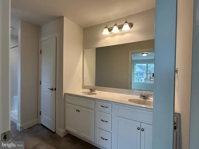 a spacious bathroom with a double vanity sink and a mirror