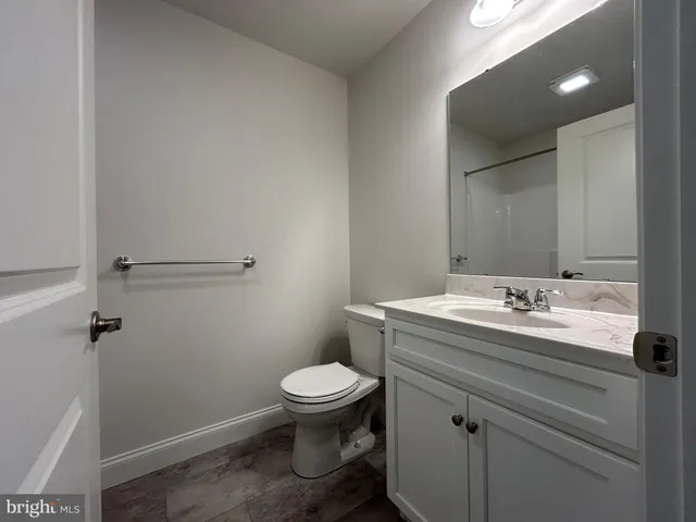 a bathroom with a granite countertop toilet and a sink