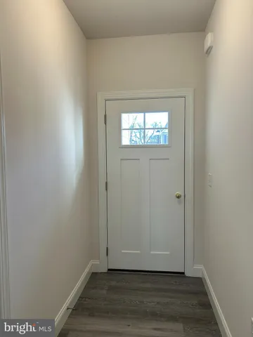 a view of an empty room with wooden floor and closet