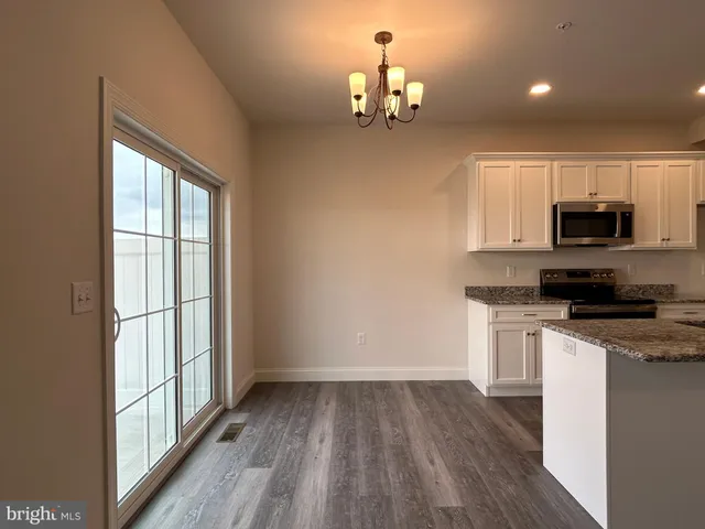a view of a kitchen with a sink microwave and cabinets
