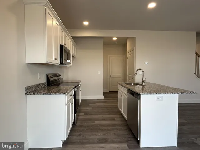 a kitchen with stainless steel appliances a sink stove top oven and cabinets