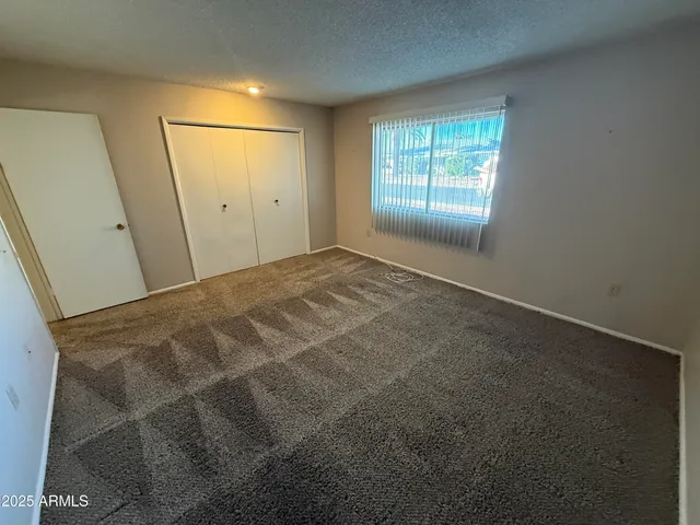 an empty room with windows and closet