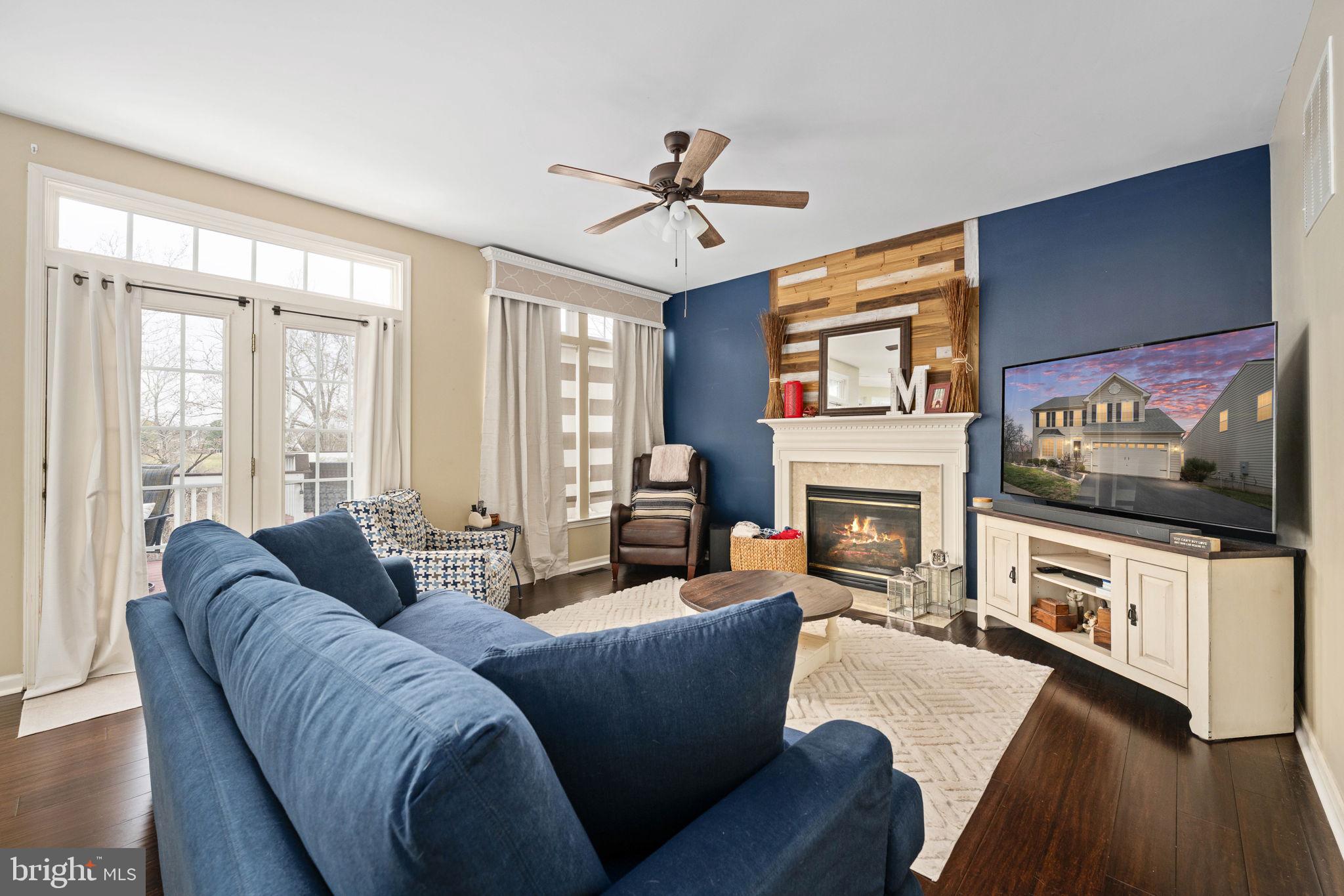 5505 Altenbury Loop Gainesville, VA 20155 - Photo 12 of 62 a living room with furniture a flat screen tv and a fireplace