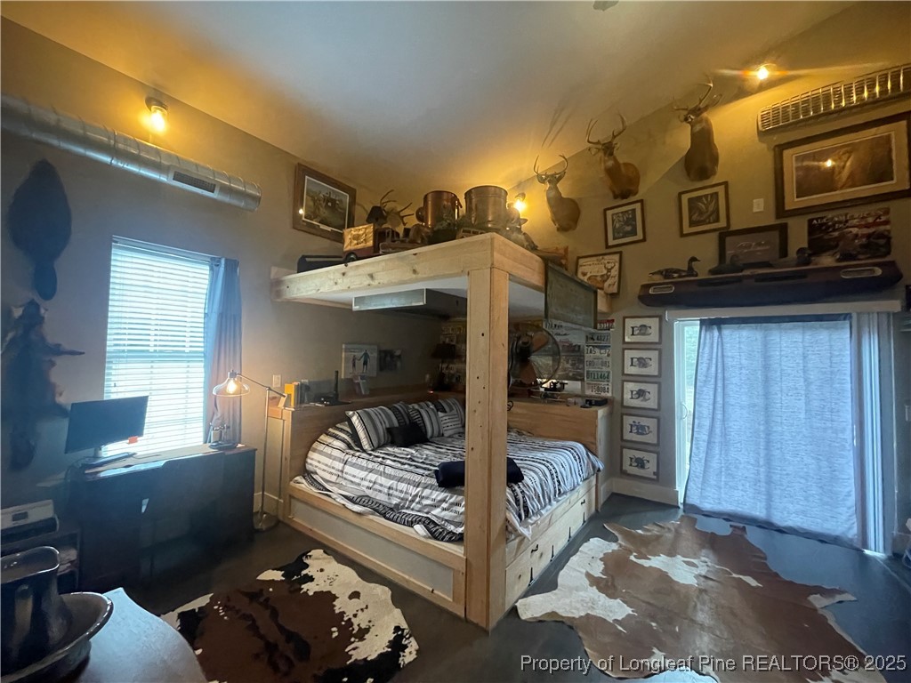 5671 Stewart Road Godwin, NC 28344 - Photo 22 of 34 a bedroom with furniture and a flat screen tv