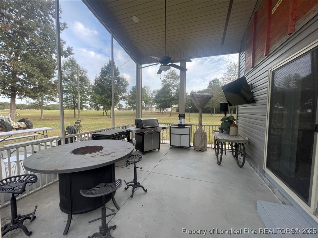 5671 Stewart Road Godwin, NC 28344 - Photo 30 of 34 a view of a patio with a dining table and chairs with a wooden fence