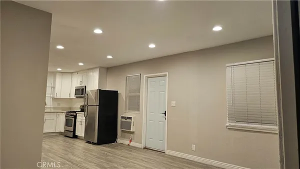 a kitchen with stainless steel appliances a refrigerator and wooden floor