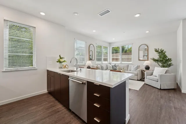 a kitchen with kitchen island granite countertop a sink and a stove top oven