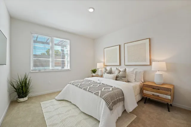 a bedroom with a two bed and a window