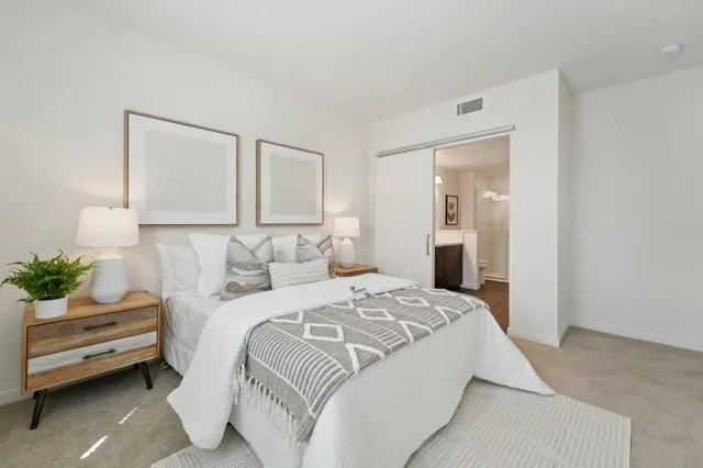 a bedroom with a bed and a potted plant