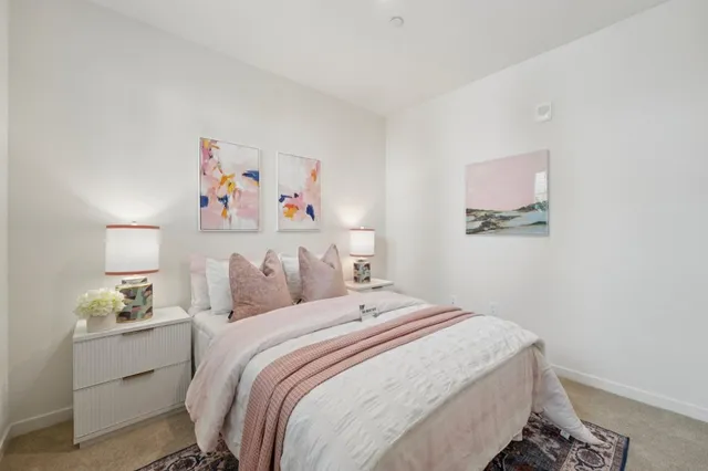 a bedroom with a bed and painting on the wall