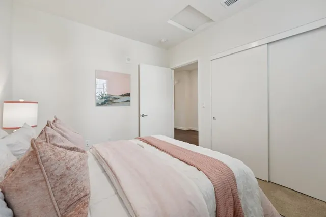 a bedroom with a bed and a lamp on the dresser