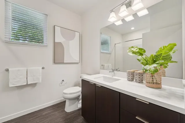 a bathroom with a granite countertop sink a toilet and a mirror