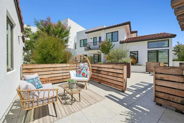 a view of a chairs setting on the deck in front of the house