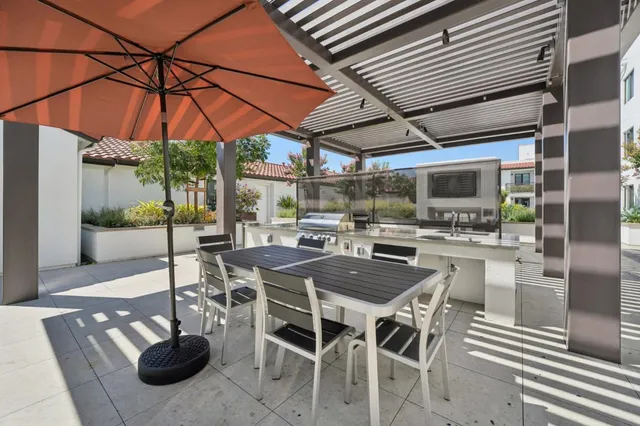 a view of a patio with couches and table and chairs with wooden fence