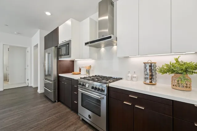 a kitchen with stainless steel appliances granite countertop a sink stove and refrigerator
