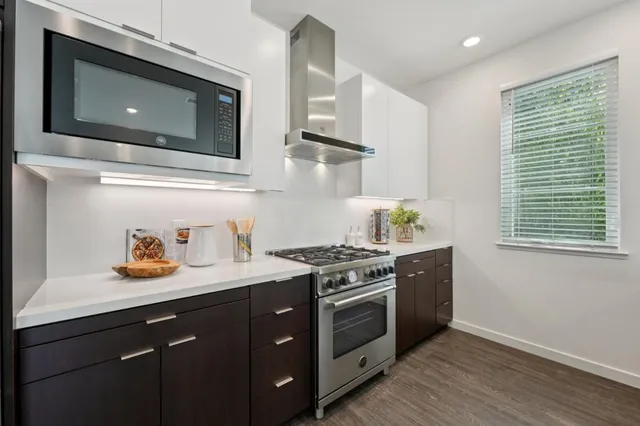 a kitchen with stainless steel appliances granite countertop a stove a sink and a microwave