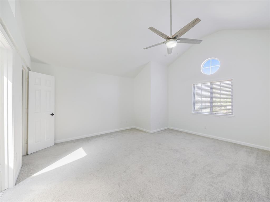 2327 North Ridge Road McKinney, TX 75072 - Photo 15 of 26 Vaulted ceiling with an integrated ceiling fan, light-toned carpeting, and a round accent window