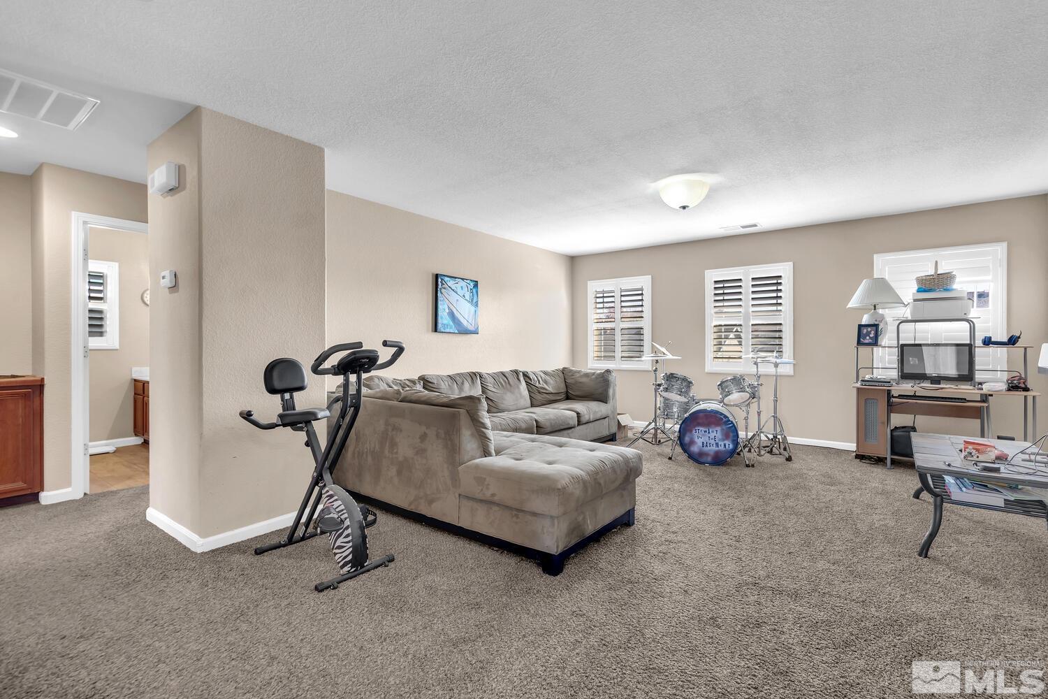 8970 Sorcha Street Reno, NV 89506 - Photo 18 of 38 a living room with furniture and a gym machine next to a window