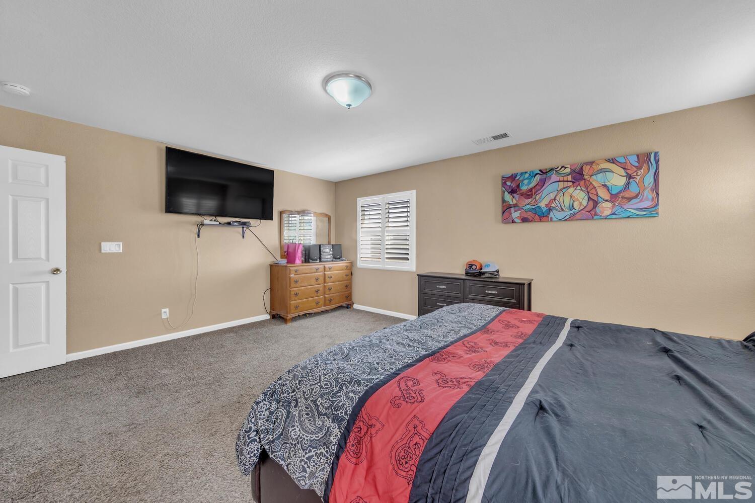 8970 Sorcha Street Reno, NV 89506 - Photo 23 of 38 a bedroom with a bed and a flat screen tv