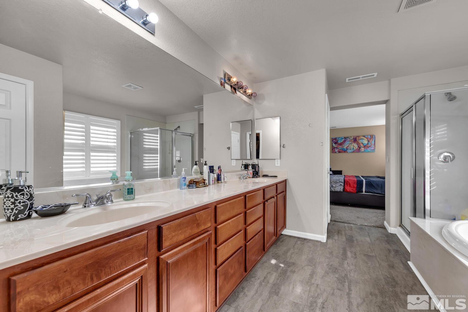 8970 Sorcha Street Reno, NV 89506 - Photo 26 of 38 a bathroom with double vanity sinks a large mirror and a shower