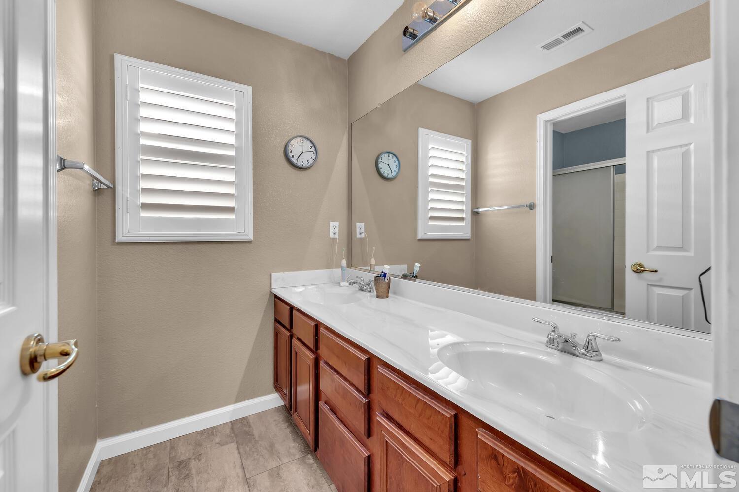 8970 Sorcha Street Reno, NV 89506 - Photo 29 of 38 a bathroom with a granite countertop sink and a mirror