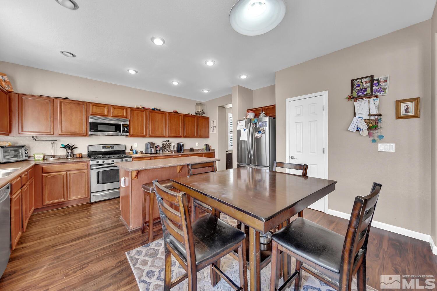 8970 Sorcha Street Reno, NV 89506 - Photo 8 of 38 a kitchen with stainless steel appliances granite countertop a stove a refrigerator a kitchen island a table and chairs