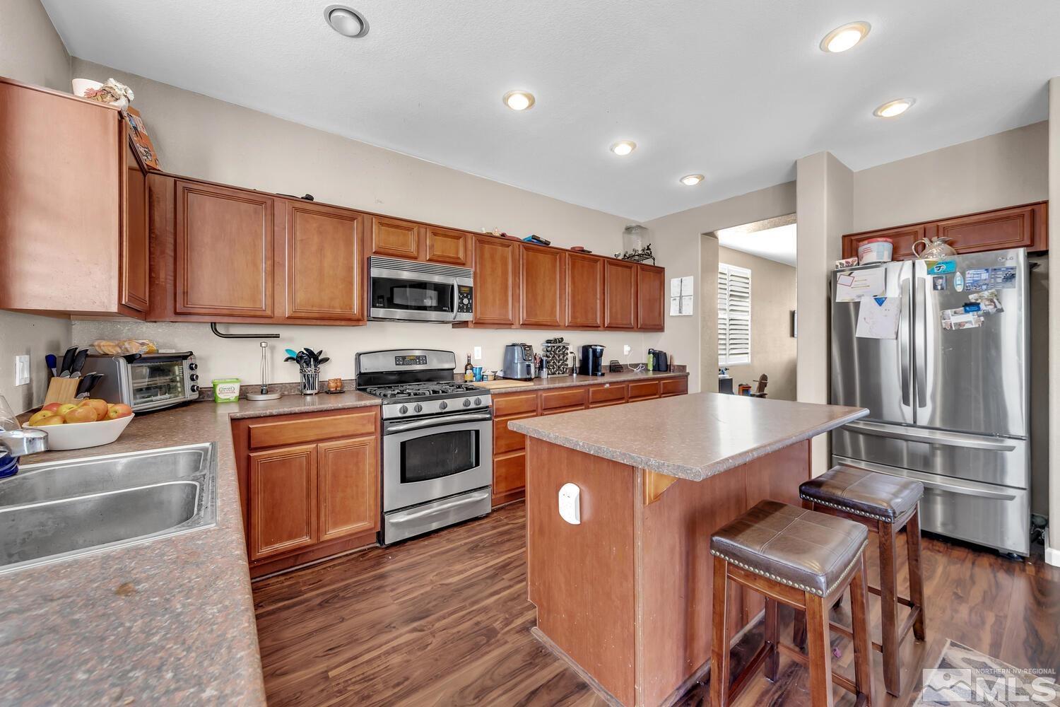 8970 Sorcha Street Reno, NV 89506 - Photo 9 of 38 a kitchen with stainless steel appliances granite countertop a refrigerator a stove top oven a sink and dishwasher