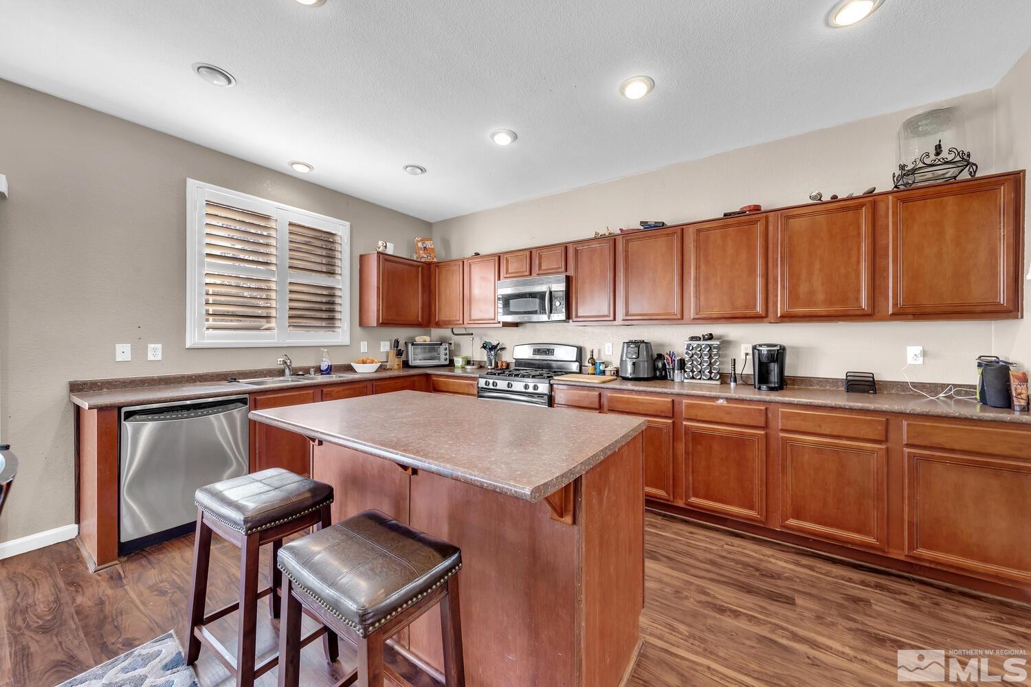 8970 Sorcha Street Reno, NV 89506 - Photo 10 of 38 a kitchen with stainless steel appliances granite countertop a stove a sink dishwasher and a refrigerator