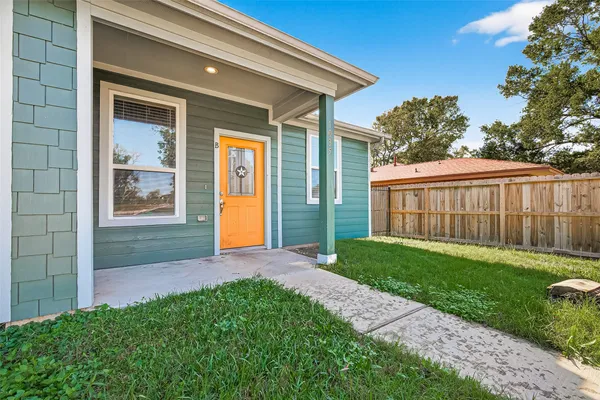 a view of a house with a yard and pathway