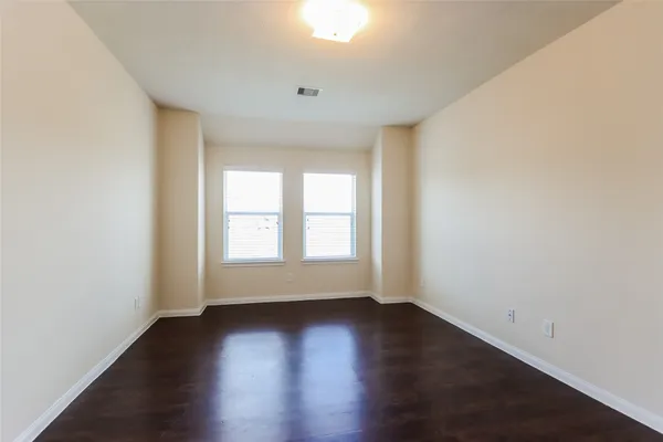 an empty room with wooden floor and window
