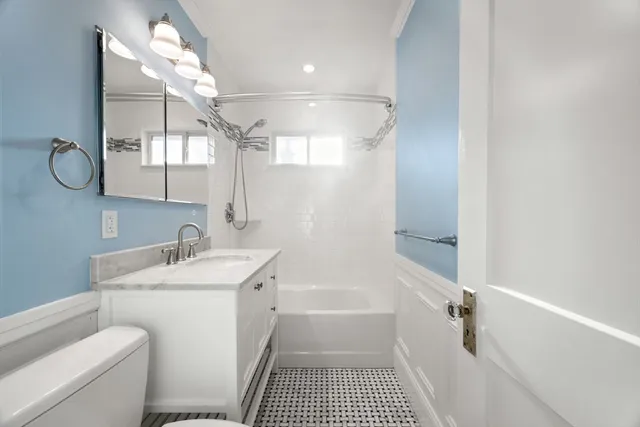 a bathroom with a sink a toilet a mirror and shower