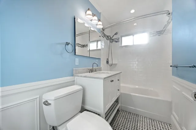 a bathroom with a sink a toilet a mirror and shower
