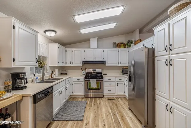 a kitchen with a refrigerator stove top oven and sink