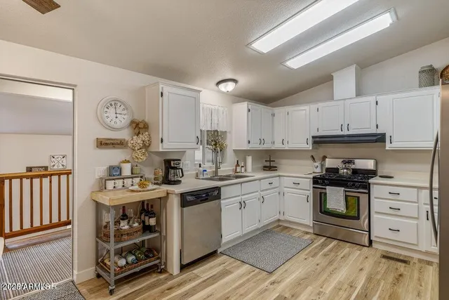 a kitchen with stainless steel appliances granite countertop a stove and cabinets