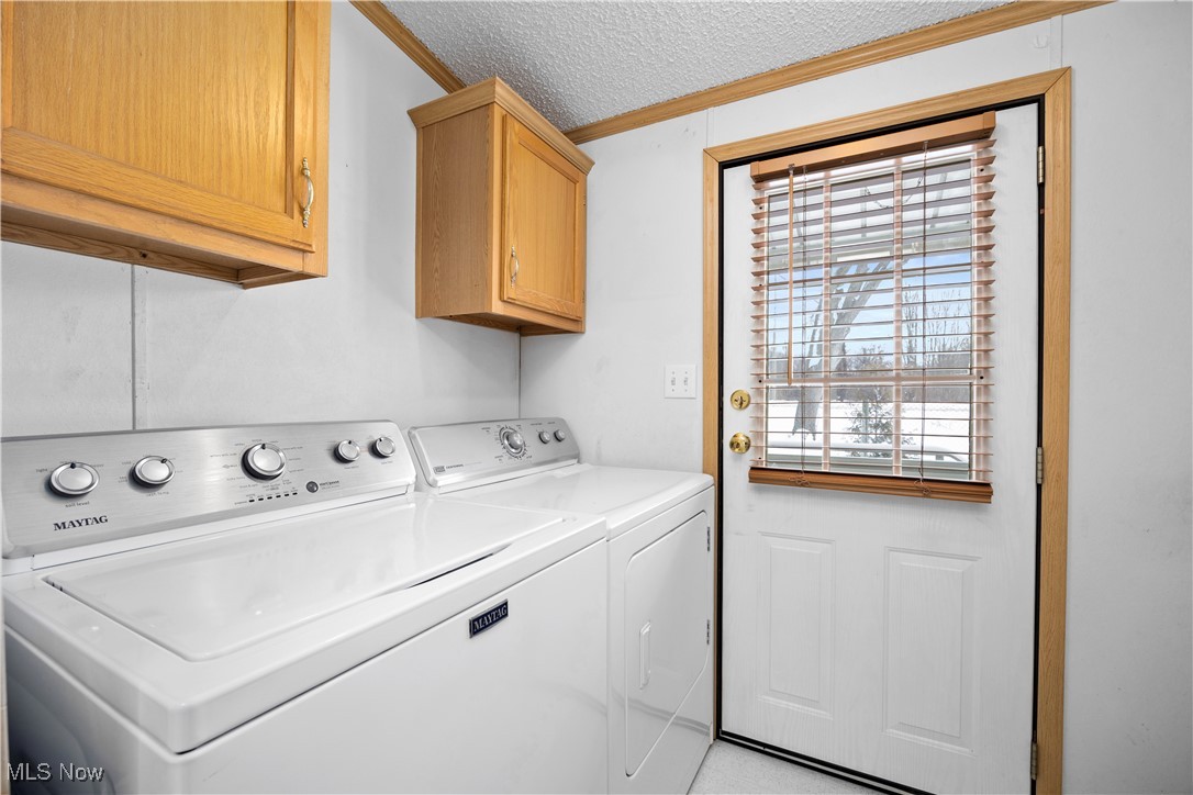 35157 Center Ridge Road, Unit 151 North Ridgeville, OH 44039 - Photo 22 of 29 Laundry room with a textured ceiling, ornamental molding, cabinet space, and washing machine and clothes dryer