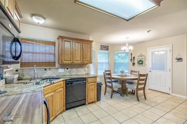 a kitchen with a sink a table and chairs in it