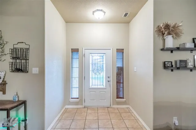 a view of an entryway with a flower pot and a bookshelf