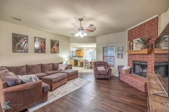 a living room with furniture a fireplace and a chandelier