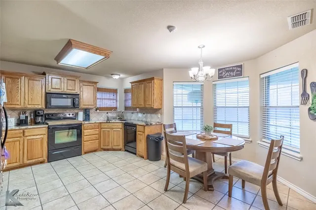 a kitchen with a stove a sink dishwasher and a refrigerator
