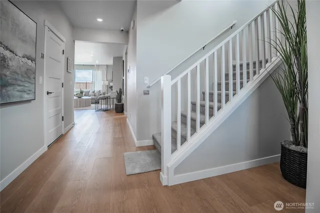 a view of a hallway with wooden floor and staircase