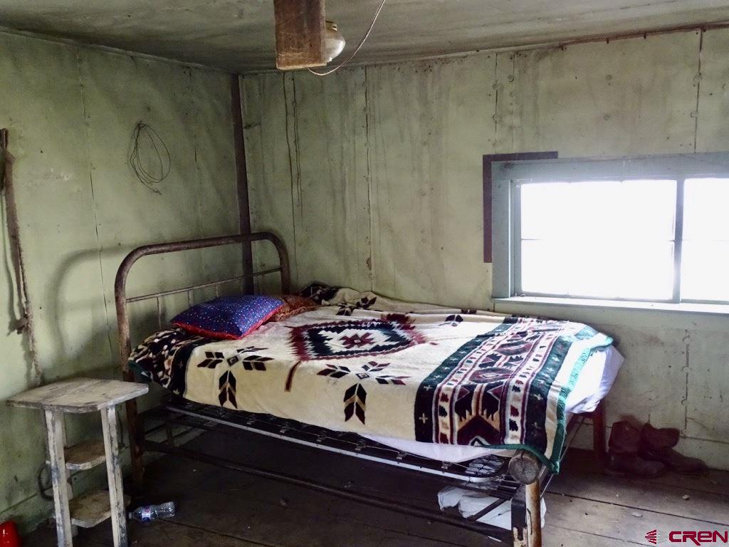 0 Groundhog Reservoir Road, Unit POND ROCK ELK & CATTLE Norwood, CO 81423 - Photo 25 of 35 a bedroom with a bed a table and chair