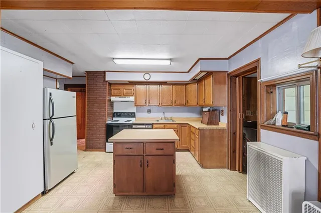 a kitchen with a refrigerator a stove top oven and cabinets