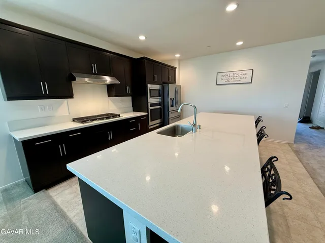 a kitchen with stainless steel appliances a sink and a refrigerator